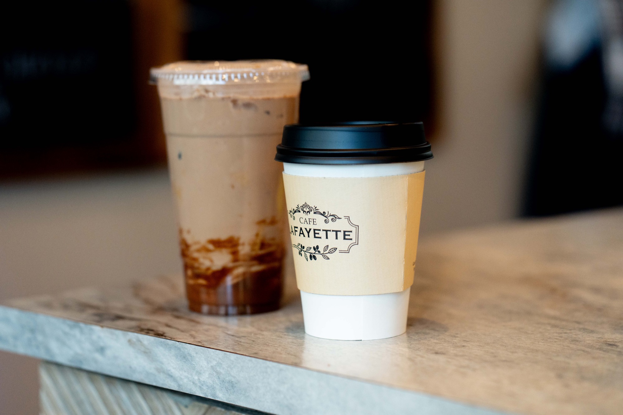 Hot coffee and an iced espresso drink on the bar