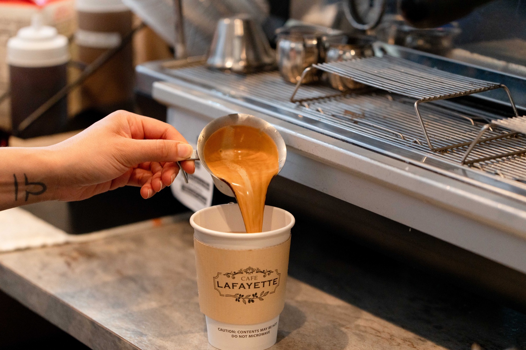 Espresso poured into a branded Cafe Lafayette cup at the bar