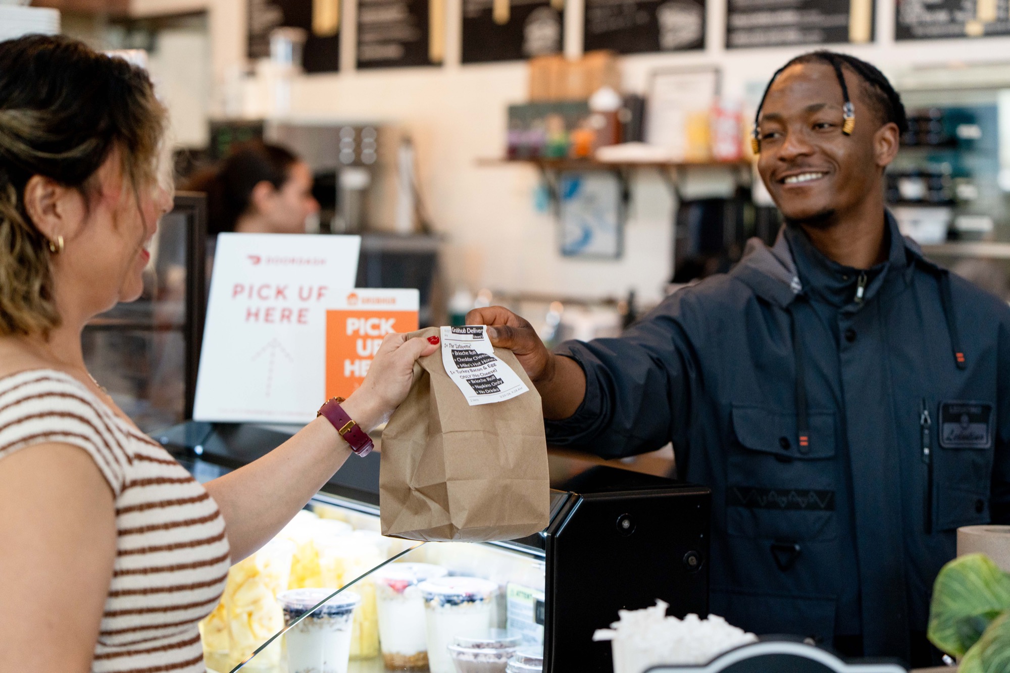 Smiling pick-up at the counter with a Cafe Lafayette to-go order